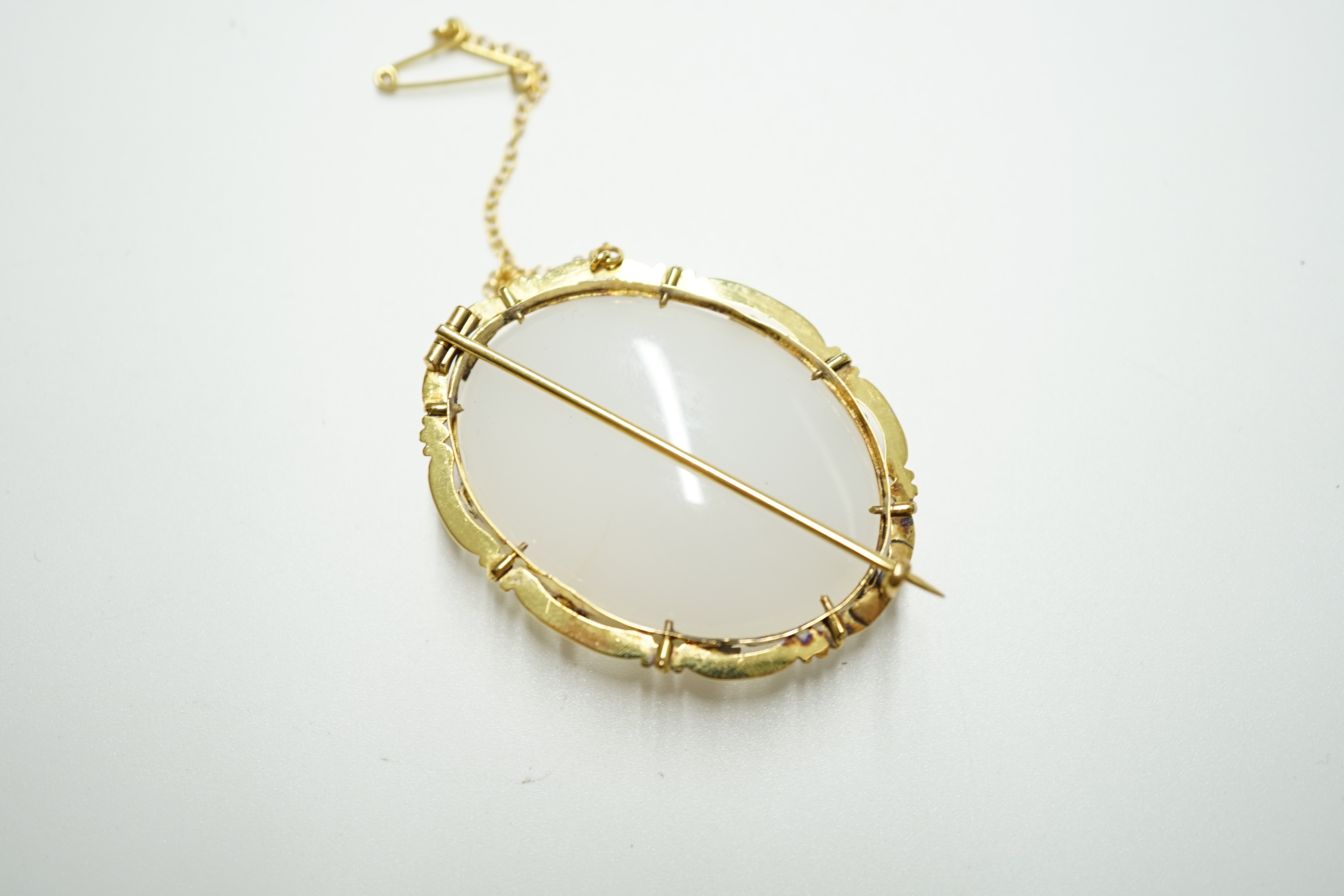 An early 20th century yellow metal mounted white chalcedony set oval brooch, 44mm, gross weight 19.6 grams. Condition - fair to good
